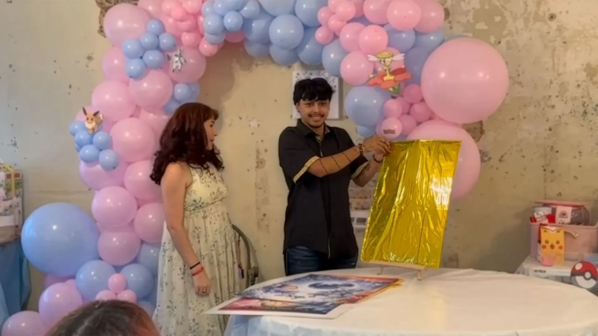 Una pareja celebra el gender reveal de su bebé con cartas Pokémon gigantes como si fuera un ''God Pack'' interactivo